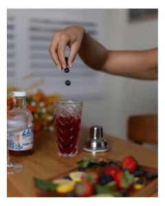 dropping blueberries into cocktail shaker